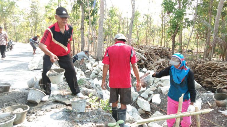 Anggota Polsek Gamping Bergantian Ikut Mengerjakan Pengurukan Jalan Desa Balecatur