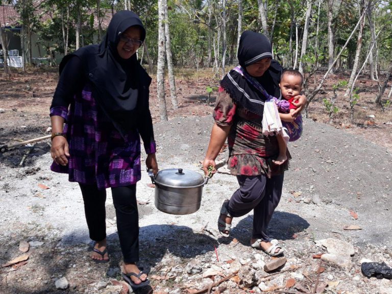 Sambil Gendong Anak, Ibu Ini Semangat Siapkan Makan untuk Satgas TMMD