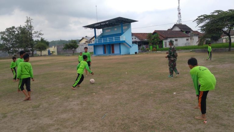 Saat Istirahat Di Manfaatkan Satgas TMMD Main Bola Bersama Anak Anak