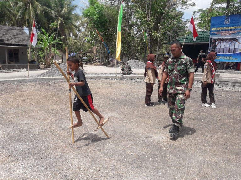 Permainan Egrang Dikenalkan Lagi Pada Anak Anak Di Kegiatan TMMD Reg 103