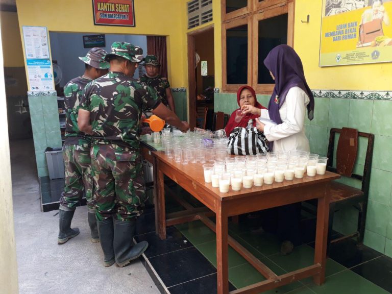 Satgas TMMD Dibantu Bu Guru Siapkan Susu Untuk Anak Anak