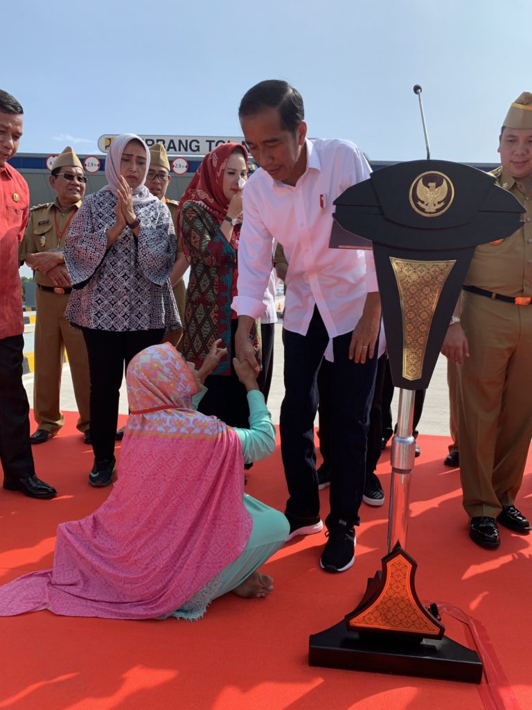 Momen Jokowi Layani Ibu Berjilbab Merah Jambu Bersalaman di Panggung